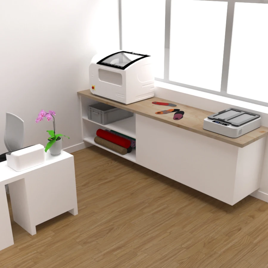 La partie fabrication et thermoformage d'un cabinet de podologie avec une cabine de thermoformage, une vitropress et des semelles posés sur un meuble et des matériaux rangés dedans.