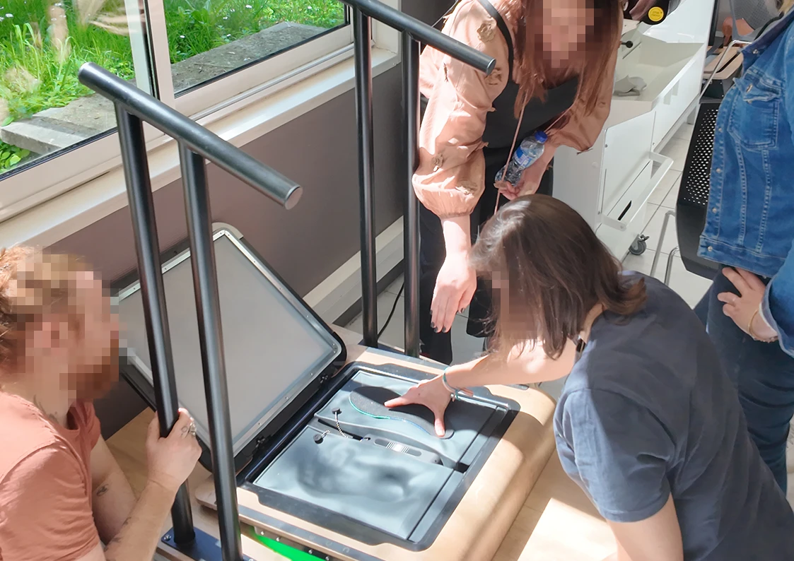 Installation d'une semelle dans un empreinteur Feet Print Capron Podologie par la formatrice avec des étudiants qui regardent