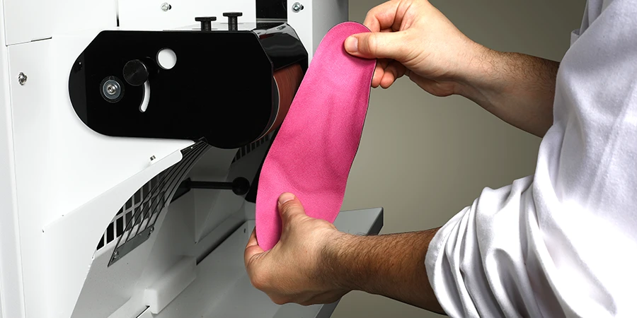 quelqu'un façonne une semelle dans le banc