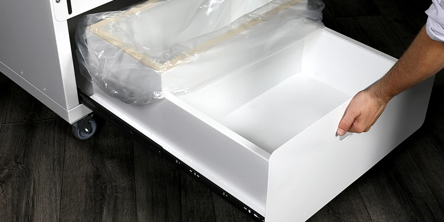 quelqu'un vide le bac du banc de façonnage