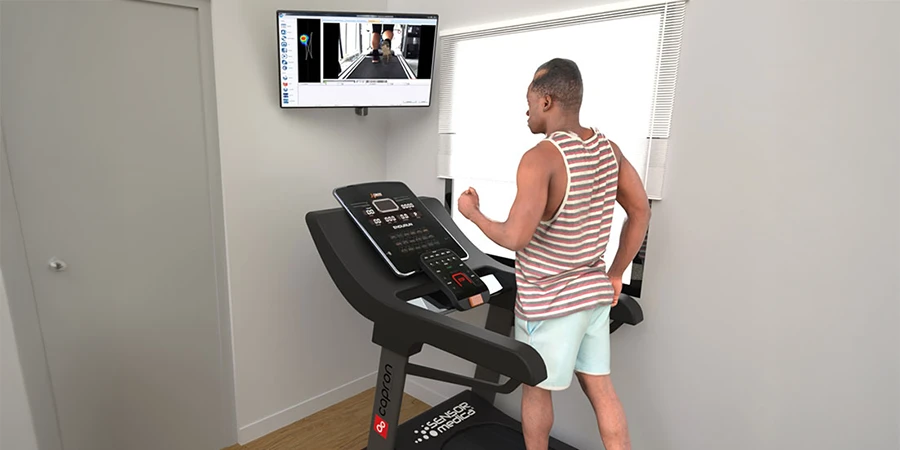patient qui marche sur un tapis de course devant une télévision avec freestep
