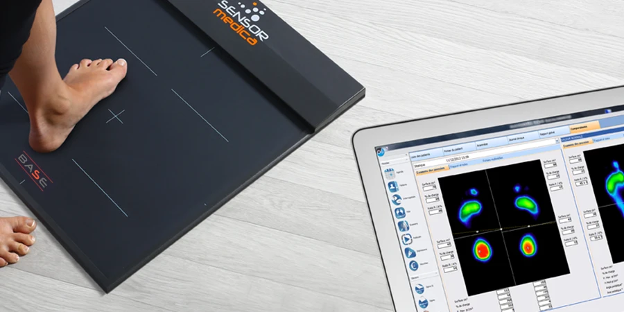 patient pieds nus qui monte sur la plateforme freemed base et affichage sur un écran du résultat de l'analyse