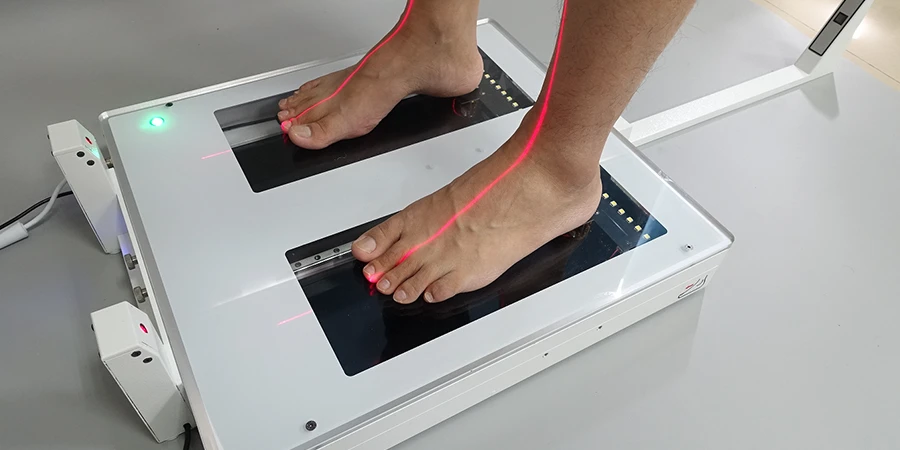 pieds nus sur le scanner 3D, on voit les lasers qui prennent l'acquisition